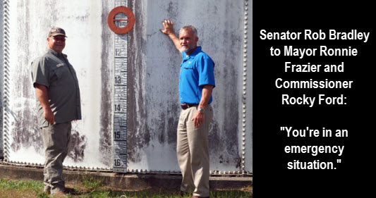 Commissioner Rocky Ford (left) and Mayor Ronnie Frazier in front of one of the at the end of their life water storage tanks in Fort White.