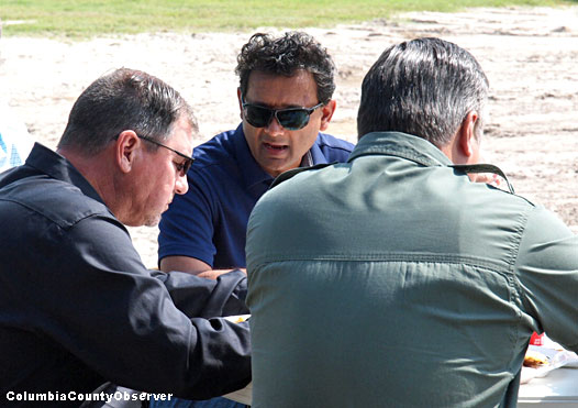 Property Appraiser Jeff Hampton (left) and hotel mogul Nick Patel converse as Sheriff Hunter enjoys his mullet and French fries.