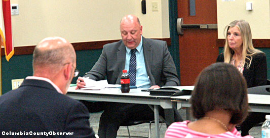 President Lawrence Barrett facing camera. on his left is Sharon Best, the college's number three person