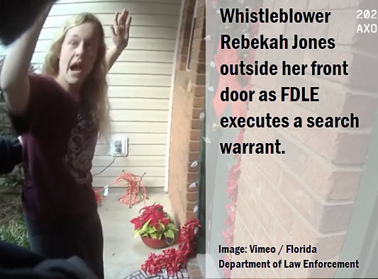 Florida Whistleblower outside her front door with hands up.