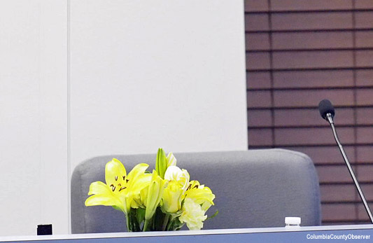 A vase of flowers in front of the seat which Ms. Coker was scheduled to fill.