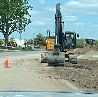 Giant backhoe in County roadway