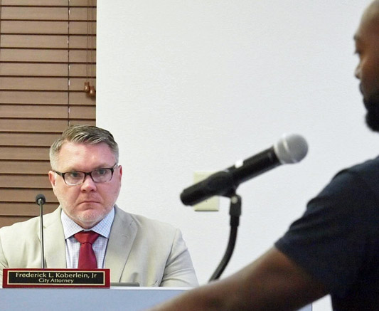 Photo of City Attorney Fred Koberlein, Jr., listening to Sylvester Warren.