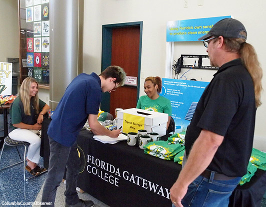 Andrew Dawson fills out a survey for free swag as Teagan Rhoden, Kristin Thomas and dad Rob Dawson look on.